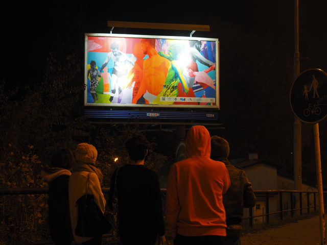 Zdjęcie; ludzie patrzący na bilbord, na którym umieszczono obraz olejny.