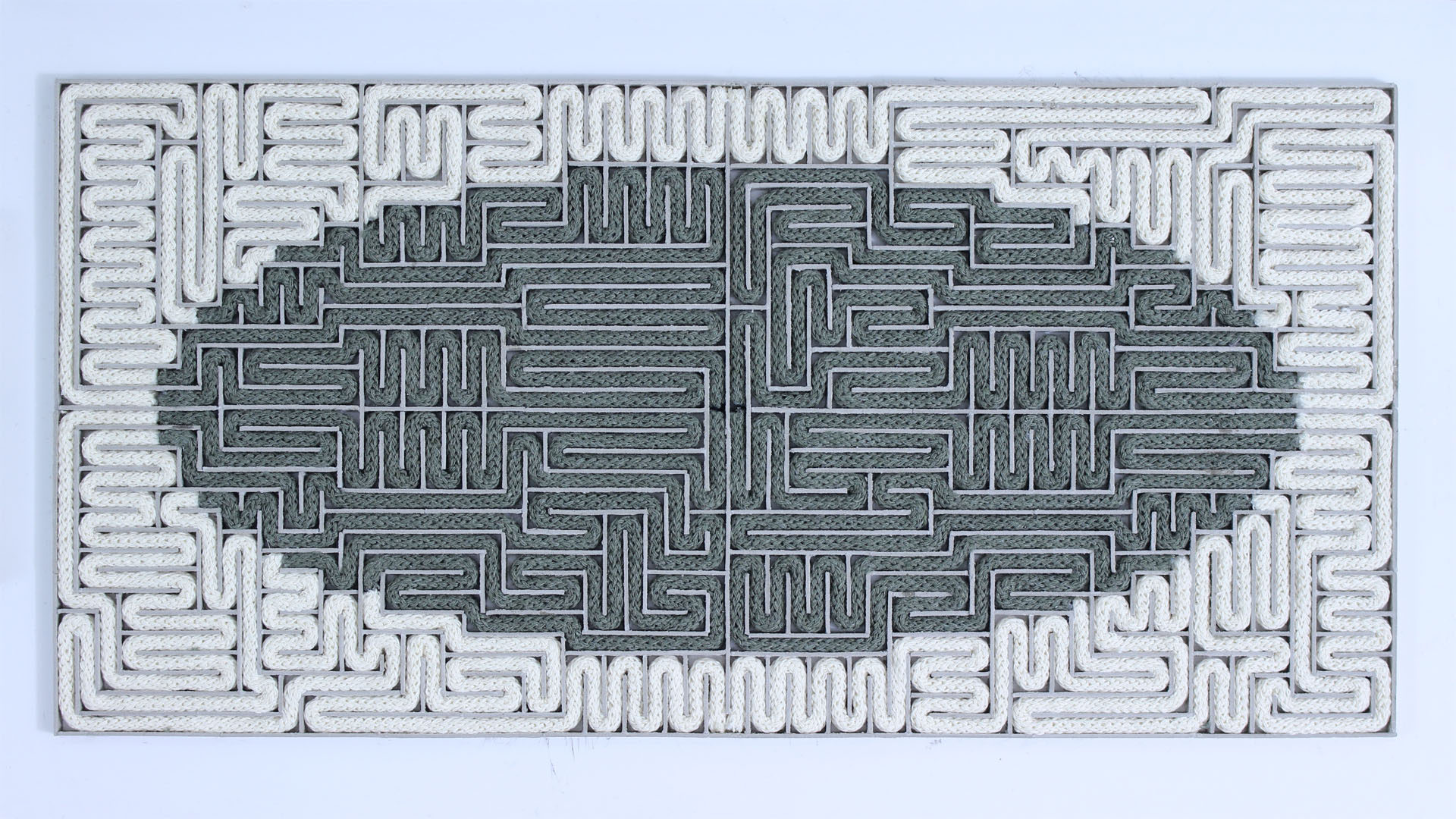 Instalacja przedstawiająca labirynt wypełniony dwoma sznurami w dwóch kolorach, jednym w środku, drugim okalającym go.