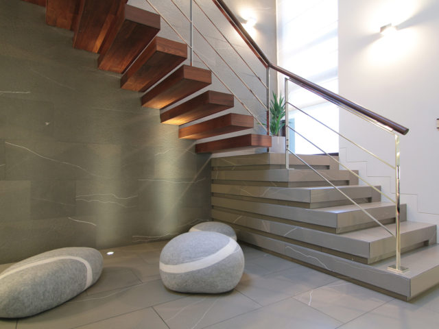 Korytarz; schody prowadzące na górne piętro, ozdoby imitujące kamienie.