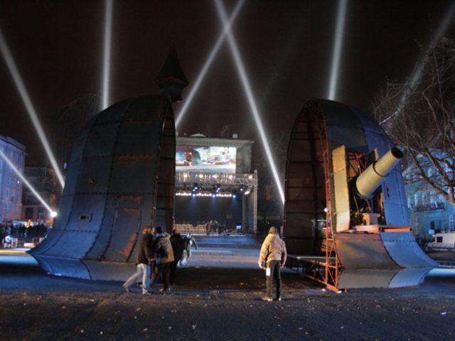 Plac Wolności w Poznaniu; instalacja w postaci wielkiej ,przepołowionej, żelaznej kopuły w iglicą na wierzchu, w tle rozstawiona scena.