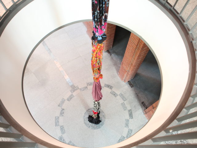 30 metrowy sznur kolorowych sukien zebranych od kobiet z Baku zawieszony na klatce.
