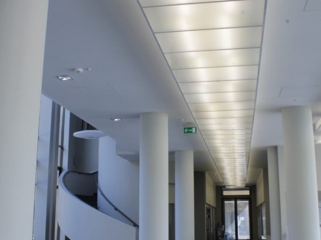 Wnętrze budynku audytoryjnego, korytarz i hol, schody na górę.