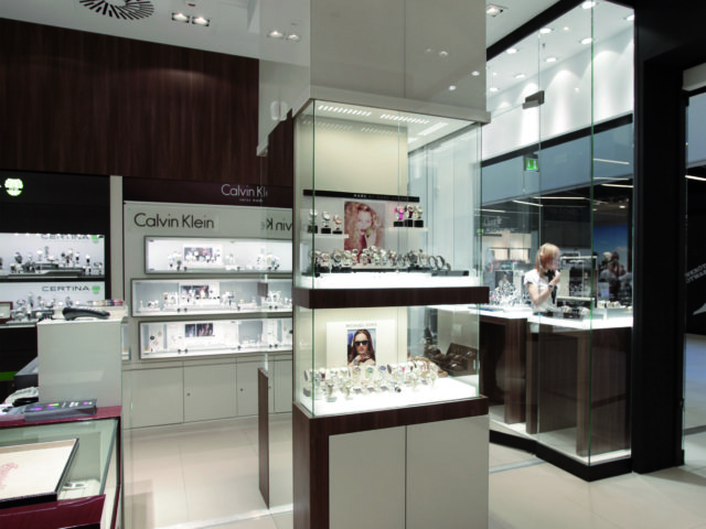 Wnętrze sklepu jubilerskiego. Oszklone ekspozycje z zegarkami i biżuterią. Logo "Calvina Kleina".