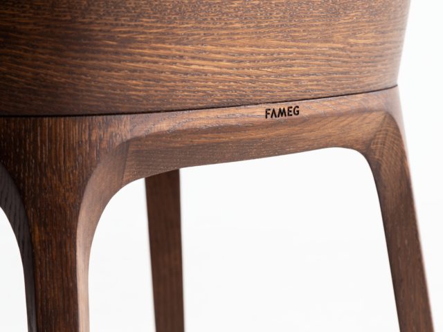 Zbliżenie na tył zaprojektowanego fotela z widoczną, wyrytą nazwą firmy "Fameg"