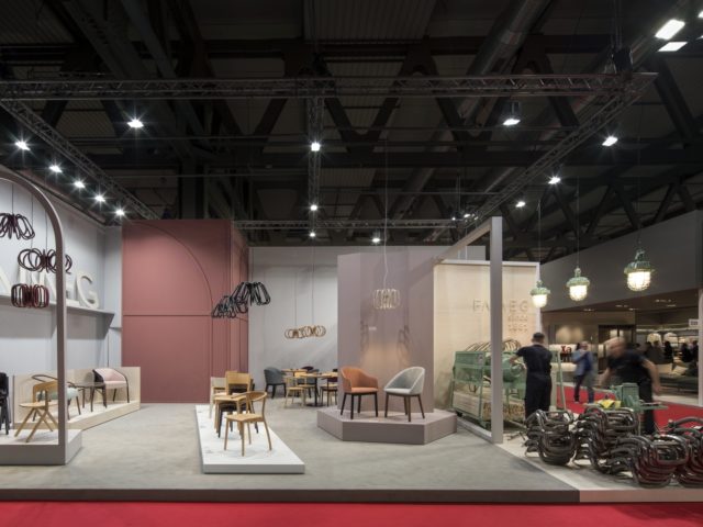 Wystawa produktów firmy "Fameg"; fotele, krzesła, stoliki, lampy i oglądający je ludzie.