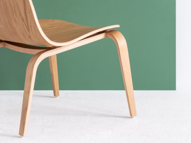 Zbliżenie na tył zaprojektowanego krzesła z widoczną, wyrytą nazwą firmy "Fameg"