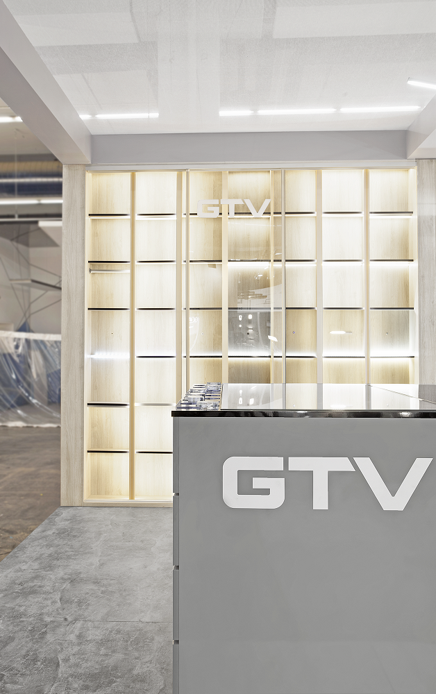 STOISKO TARGOWE firmy GTV; otwarty boks z interaktywnym stołem,  stolikiem z krzesłami i ekranem na ścianie oraz oszklonym pokojem.