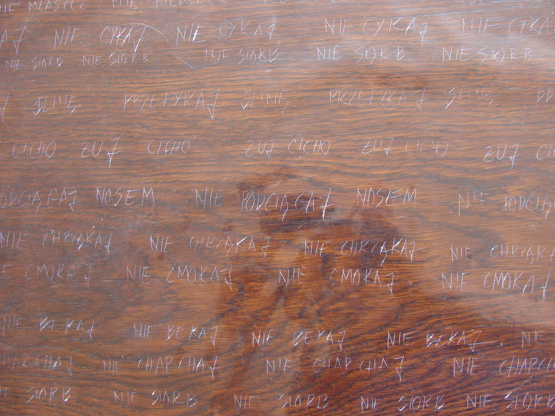 Napisy wyryte igłą w drewnie.