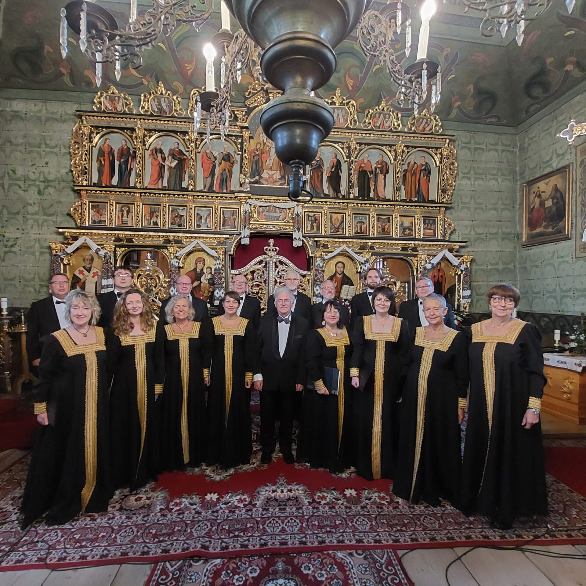 Chóru Kameralnego Członkowie chóru Cappella Musicae Antiquae Orientalis ubrani w czarne stroje i stojący na tle ikonostasu w kościele prawosławnym